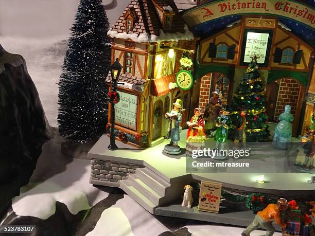 model victorian 'dickens' christmas village with miniature houses, people, winter-scene - victorian scrooge stock pictures, royalty-free photos & images
