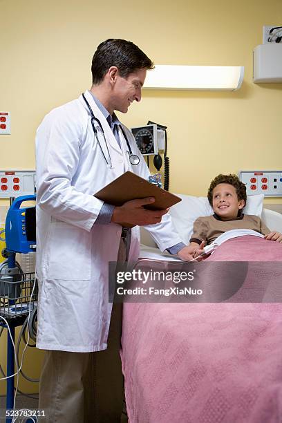 pediatric doctor with child patient in bed - children's hospital stock pictures, royalty-free photos & images