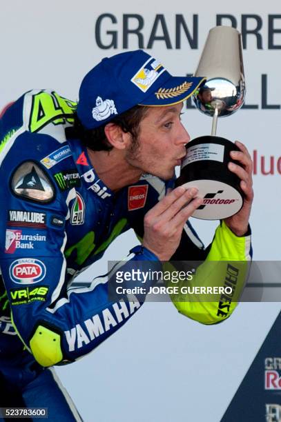 Winner Movistar Yamaha MotoGP's Italian rider Valentino Rossi kisses his trophy on the podium of the MotoGP race of the Spanish Moto Grand Prix at...