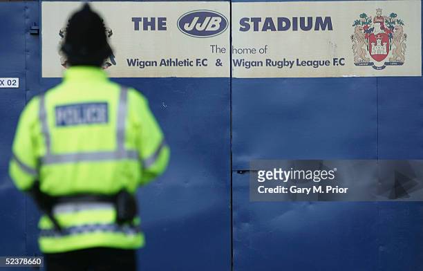 Amid threats of ground closure by Greater Manchester police a policeman patrols outside the JJB Stadium before the Coca-Cola Championship match...