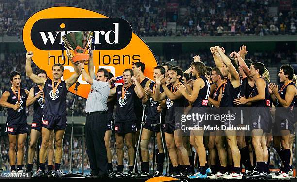 Anthony Koutoufides and Denis Pagan coach of the Blues hold the trophy after winning the AFL Wizard Cup Grand Final between the Carlton Blues and the...