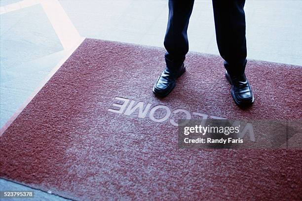 businessman standing on welcome mat - doormat stock pictures, royalty-free photos & images