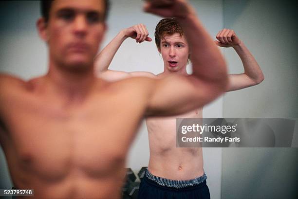 men flexing their muscles - weak men stock-fotos und bilder