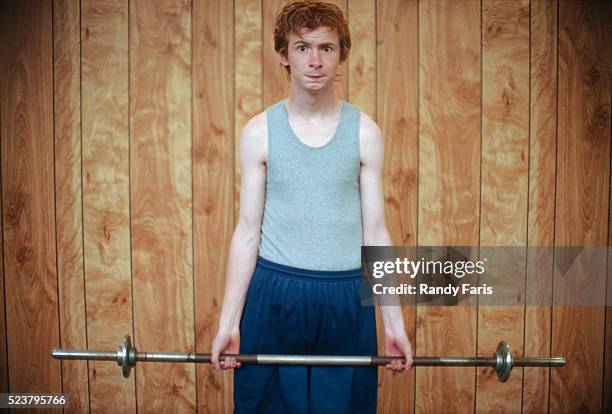 young man struggling with weight bar - indecisive stock-fotos und bilder