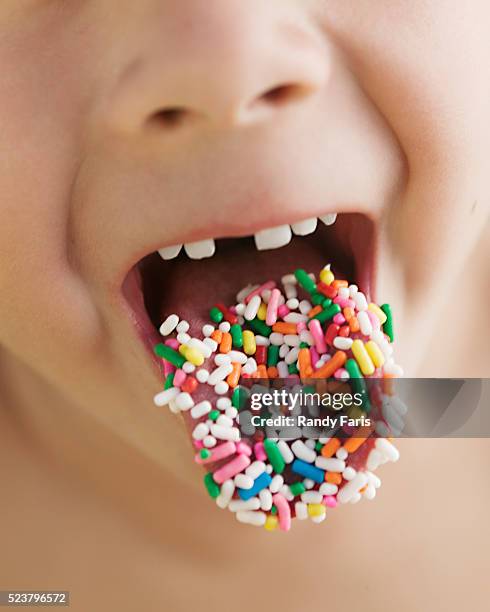 boy with candy sprinkles on his tongue - candy on tongue stock pictures, royalty-free photos & images
