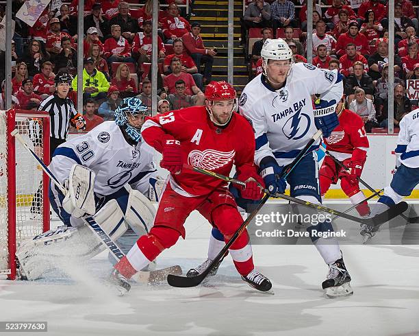 Ben Bishop of the Tampa Bay Lightning follows the play as teammate Andrej Sustr battles with Pavel Datsyuk of the Detroit Red Wings in Game Four of...