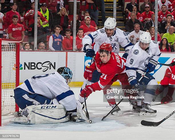 Ben Bishop of the Tampa Bay Lightning covers the puck as teammates Brian Boyle and Tyler Johnson battle with Dylan Larkin of the Detroit Red Wings in...