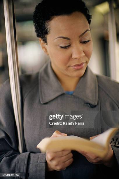 businesswomen reading book on train - monorail interior stock pictures, royalty-free photos & images