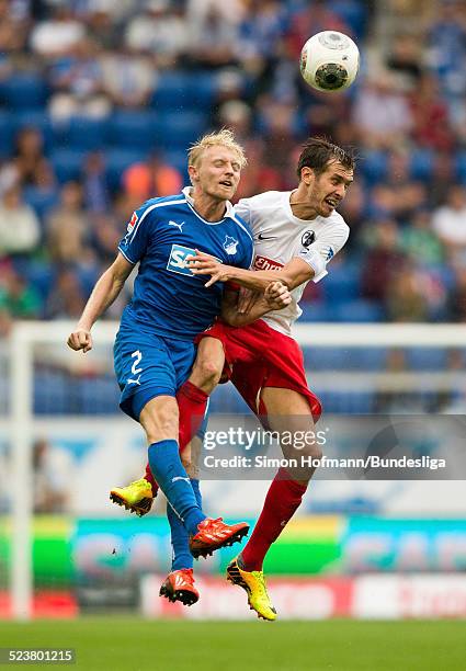 Andreas Beck of Hoffenheim jumps for a header with Julian Schuster of Freiburg during the Bundesliga match between 1899 Hoffenheim and SC Freiburg at...
