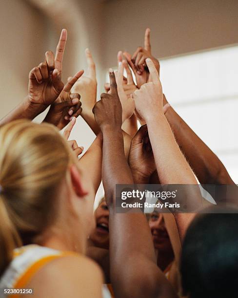 basketball players cheering in a huddle - team huddle stock-fotos und bilder