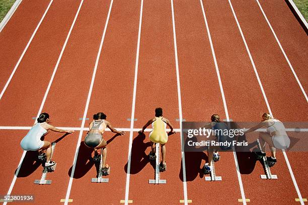 runners crouching at starting line - track starting block stock pictures, royalty-free photos & images