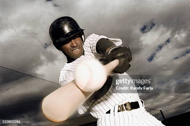 baseball player hitting ball - at bat stockfoto's en -beelden