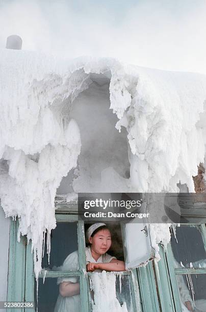 woman looks down from an iced window - sakha republic ストックフォトと画像