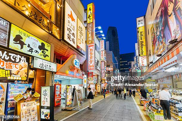 illuminated streets of shinjuku at night, tokyo, japan - distrito de shibuya fotografías e imágenes de stock