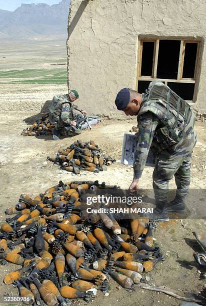 French soldiers from the International Security Assistance Force check through discarded munitions on the Shomali Plain, some 30 kms north of Kabul,...