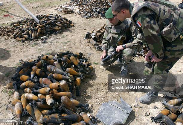 French soldiers from the International Security Assistance Force check through discarded munitions on the Shomali Plain, some 30 kms north of Kabul,...