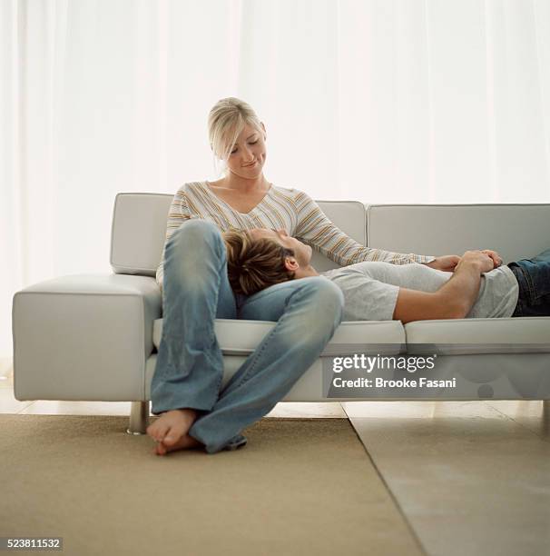 couple relaxing on sofa - auf dem schoß stock-fotos und bilder