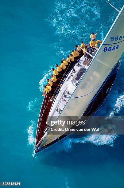 sailing team sitting on edge of boat - sailing teamwork stock pictures, royalty-free photos & images