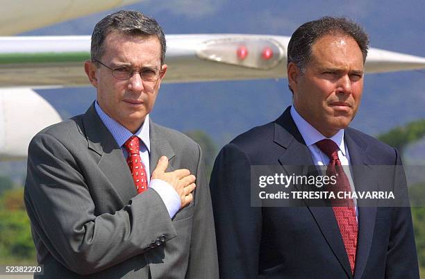 Alvaro Uribe , presidente de Colombia y Samuel Lewis, vicepresidente y ministro de Relaciones Exteriores de Panama, escuchan los himnos nacionales de...