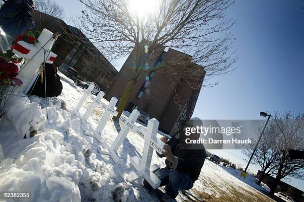 Greg Zanis of Aurora, Illinois writes the names of shooting victims on white crosses at a makeshift memorial outside of the Sheraton Hotel March 13,...