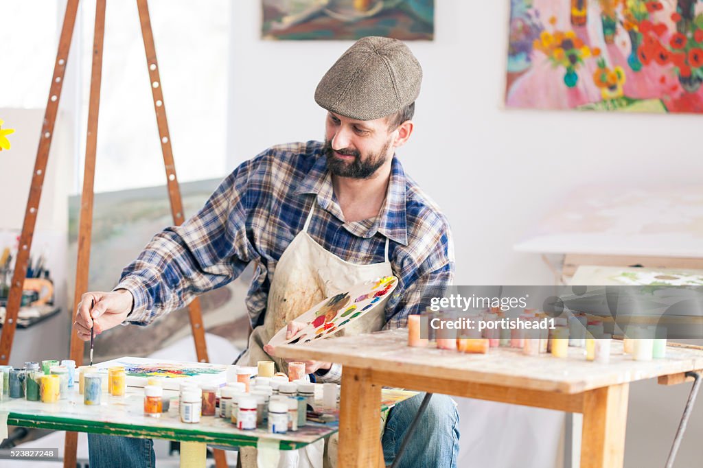 Fine artist painting at his workshop