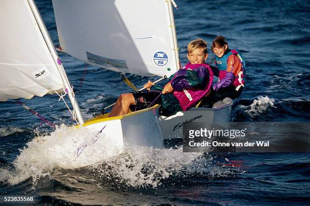 girl and boy sailing dinghys - kid sailing imagens e fotografias de stock