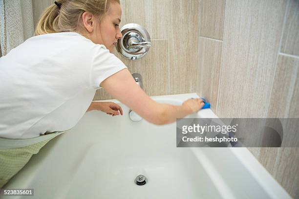 young woman cleaning bathroom with green cleaning products - heshphoto - fotografias e filmes do acervo