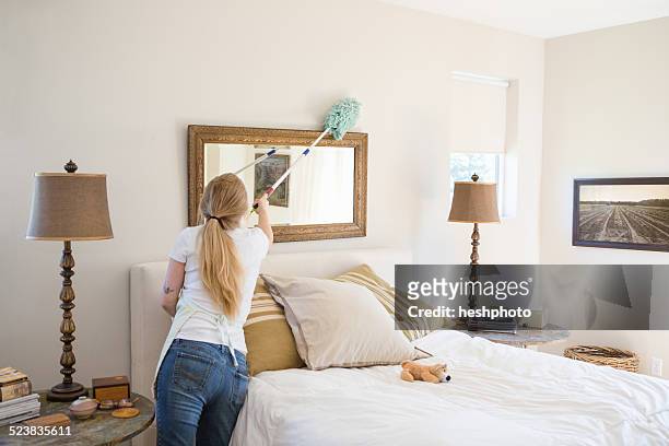 young woman cleaning bedroom with green cleaning products - heshphoto - fotografias e filmes do acervo