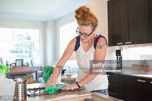 young woman cleaning kitchen with green cleaning products - heshphoto - fotografias e filmes do acervo