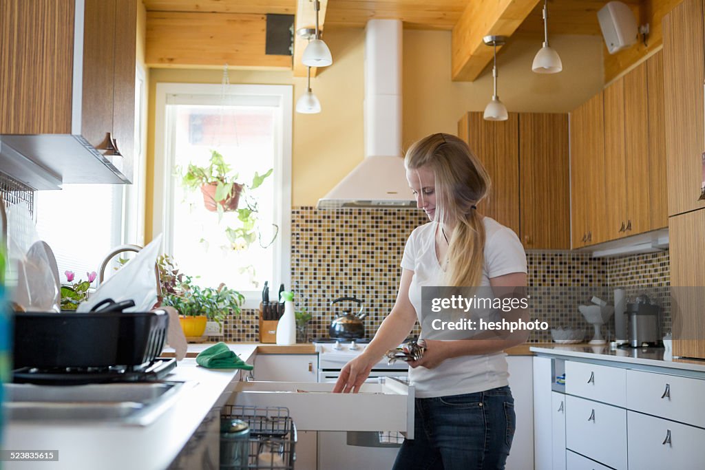 Young woman cleaning kitchen with green cleaning products