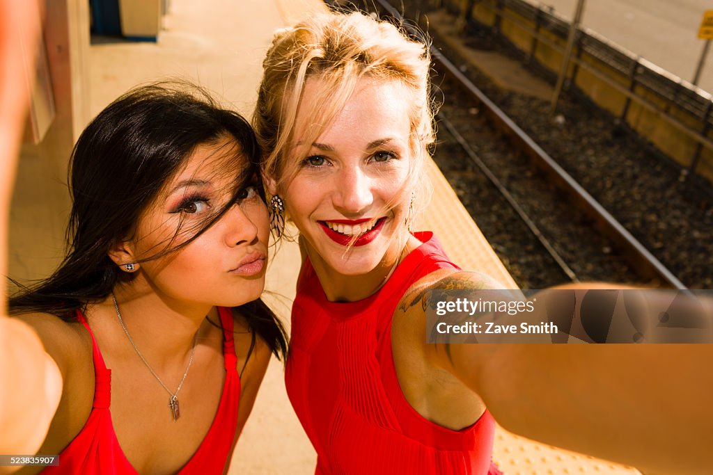 Two young women taking selfie on station platform