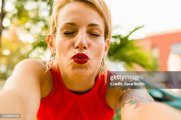 portrait of young woman in red posing for selfie - blowing a kiss stock pictures, royalty-free photos & images