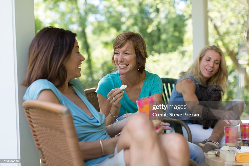 Three mature woman eating and drinking together