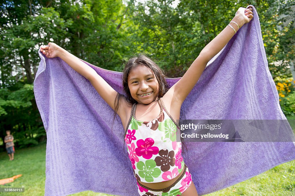 Girl in swimming costume holding towel