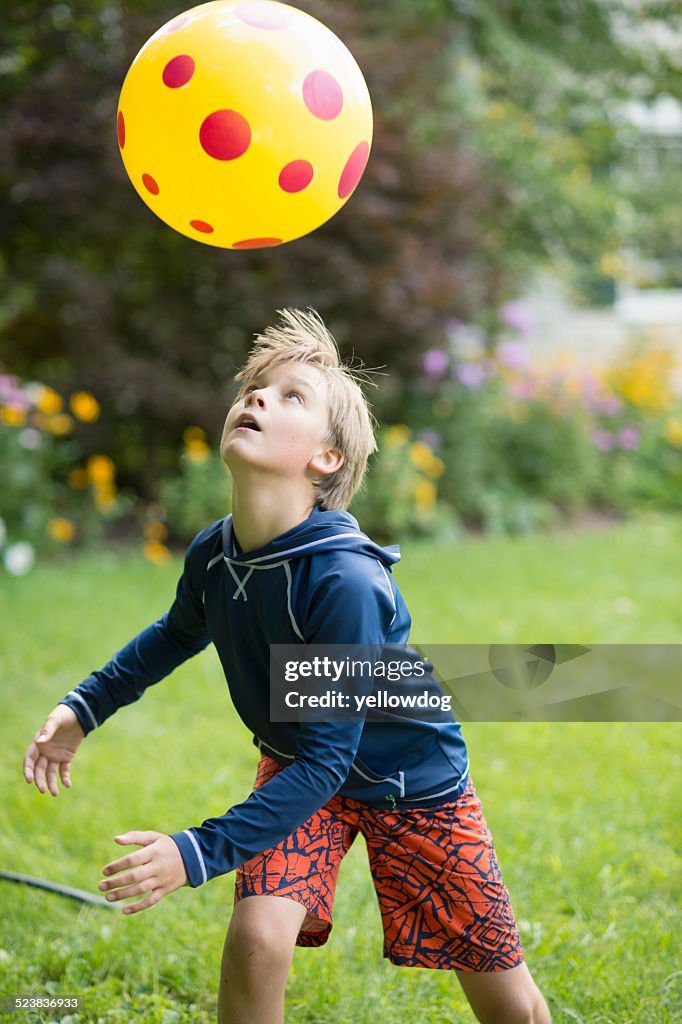 Boy playing with ball game in garden