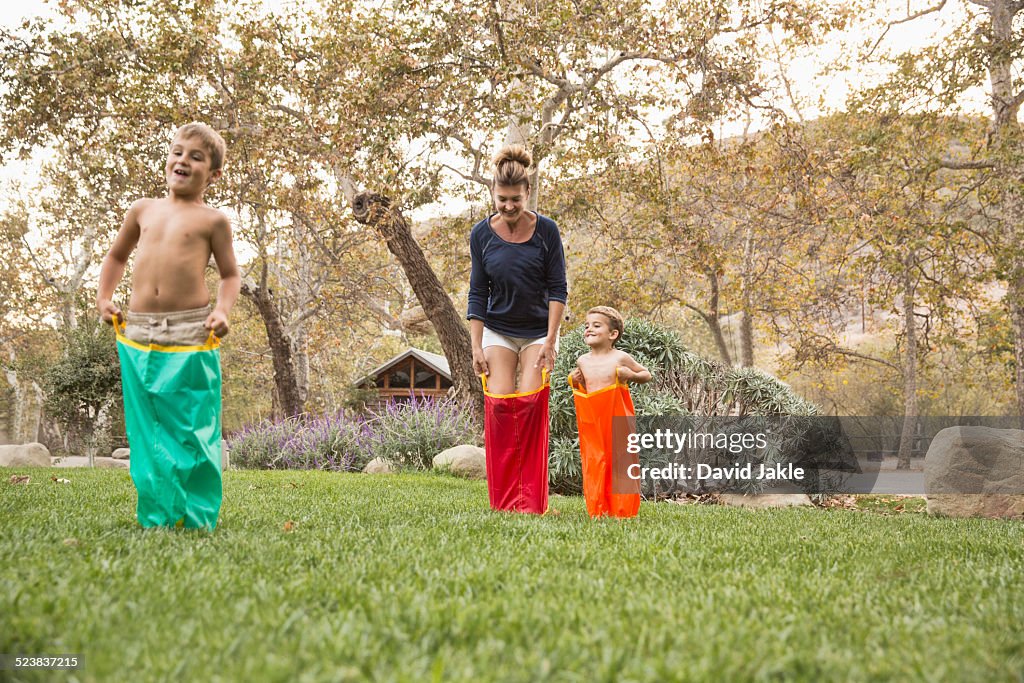 Mother and two sons having a sack race, County Park, Los Angeles, California, USA