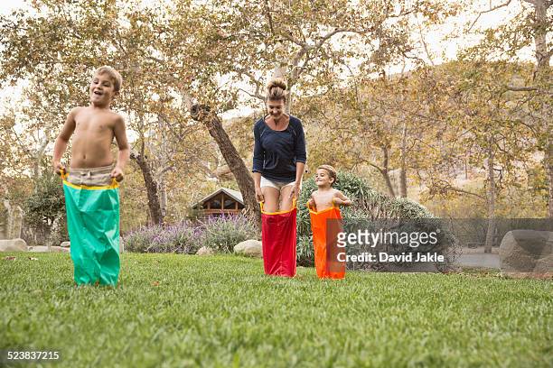 mother and two sons having a sack race, county park, los angeles, california, usa - sack race stock pictures, royalty-free photos & images