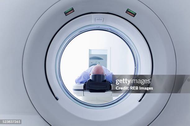 patient lying down on ct scanner - ct scanner stockfoto's en -beelden