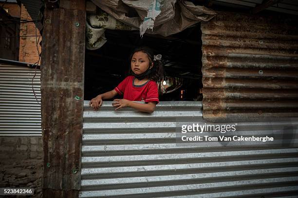 Girl in an open window of a typical metal sheet temporary shelter in Bhaktapur on April 24, 2016 in Kathmandu, Nepal. A 7.8-magnitude earthquake...