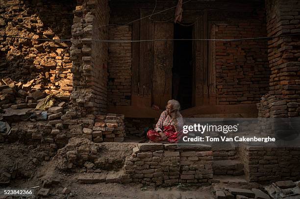 Harsha Maya sits in front of her severely damaged home in the center of Bhaktapur on April 24, 2016 in Kathmandu, Nepal. She doesn't know her age but...