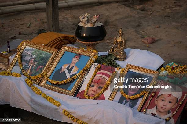 Portraits are adorned with marigold garlands and given offers of fruit during a Buddhist ceremony to commemorate those in the pictures that died...