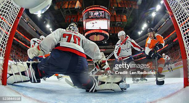 Nicklas Backstrom of the Washington Capitals defends goaltender Braden Holtby against the attack of Ryan White of the Philadelphia Flyers in Game Six...