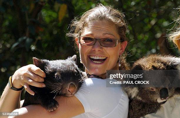 Crown Princess Victoria of Sweden laughs as she holds a wombat and is shown a koala during a visit to Healsville Sanctuary near Melbourne, 14 March...