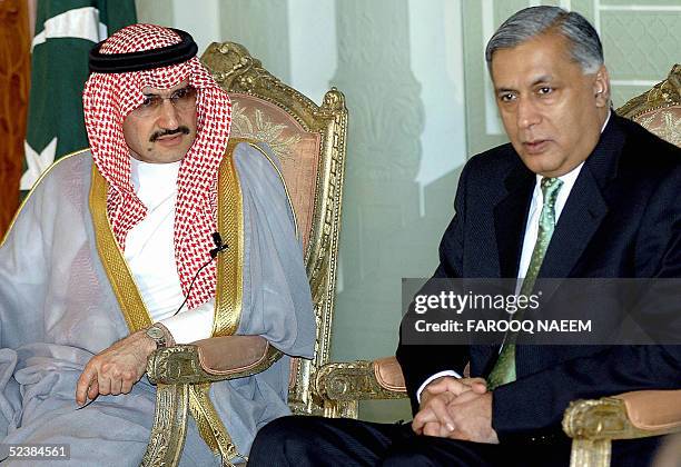 Pakistani Prime Minister Shaukat Aziz looks on as Saudi Prince Al Waleed bin Talal al Saud answers a question during a press briefing in Islamabad,...