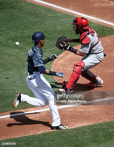 Alexei Ramirez of the San Diego Padres scores ahead of the throw to Yadier Molina of the St. Louis Cardinals during the second inning of a baseball...