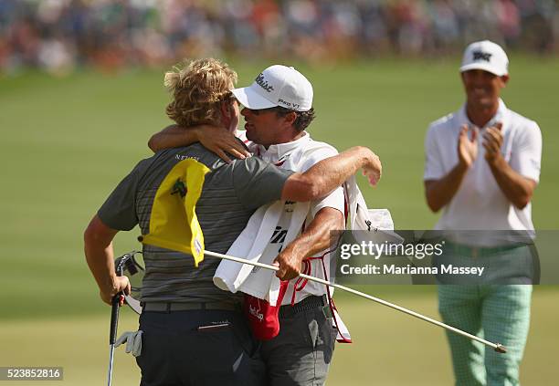 Charley Hoffman celebrates with his caddie Brett Waldman after putting on the 18th hole during the final round of the Valero Texas Open at TPC San...