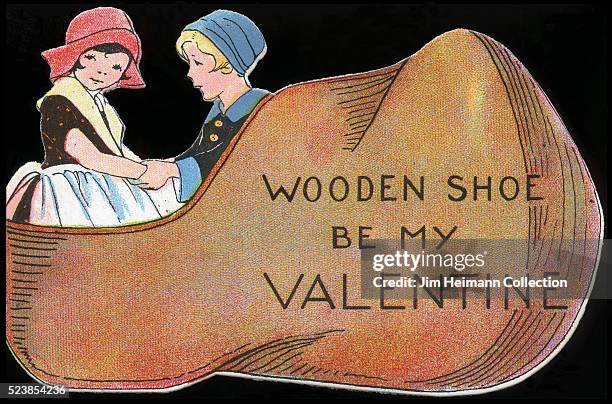 Illustration for a die-cut Valentine's Day card featuring young boy and girl sitting in wooden shoe.