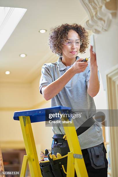 female electrician - installing ceiling light fixture stock pictures, royalty-free photos & images