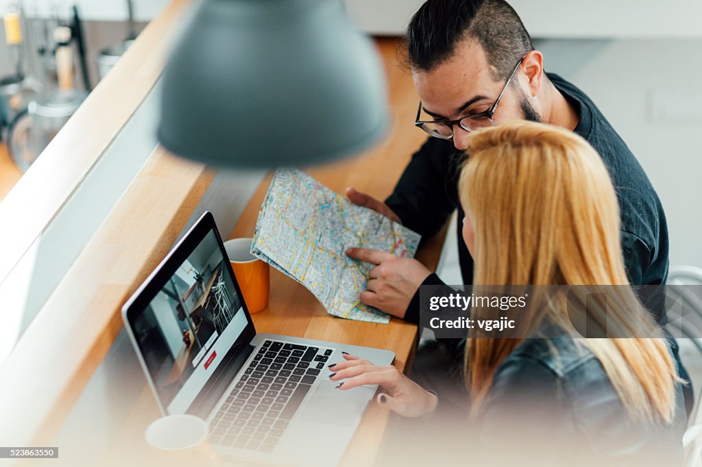 Backpackers Looking For Apartment On Their Laptop.