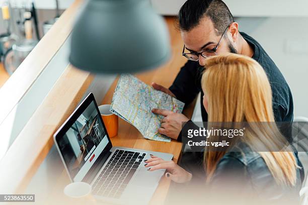 backpackers looking for apartment on their laptop. - backpacker apartment stock pictures, royalty-free photos & images